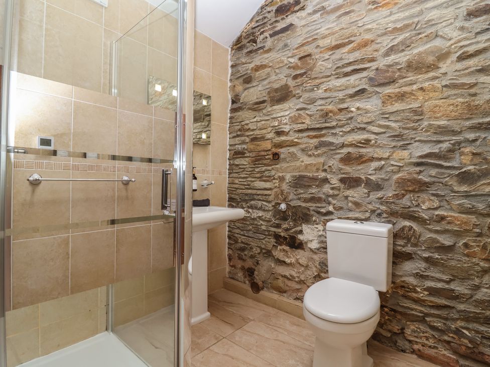 A bathroom with a shower, toilet, and sink at The Coach House in Tavistock