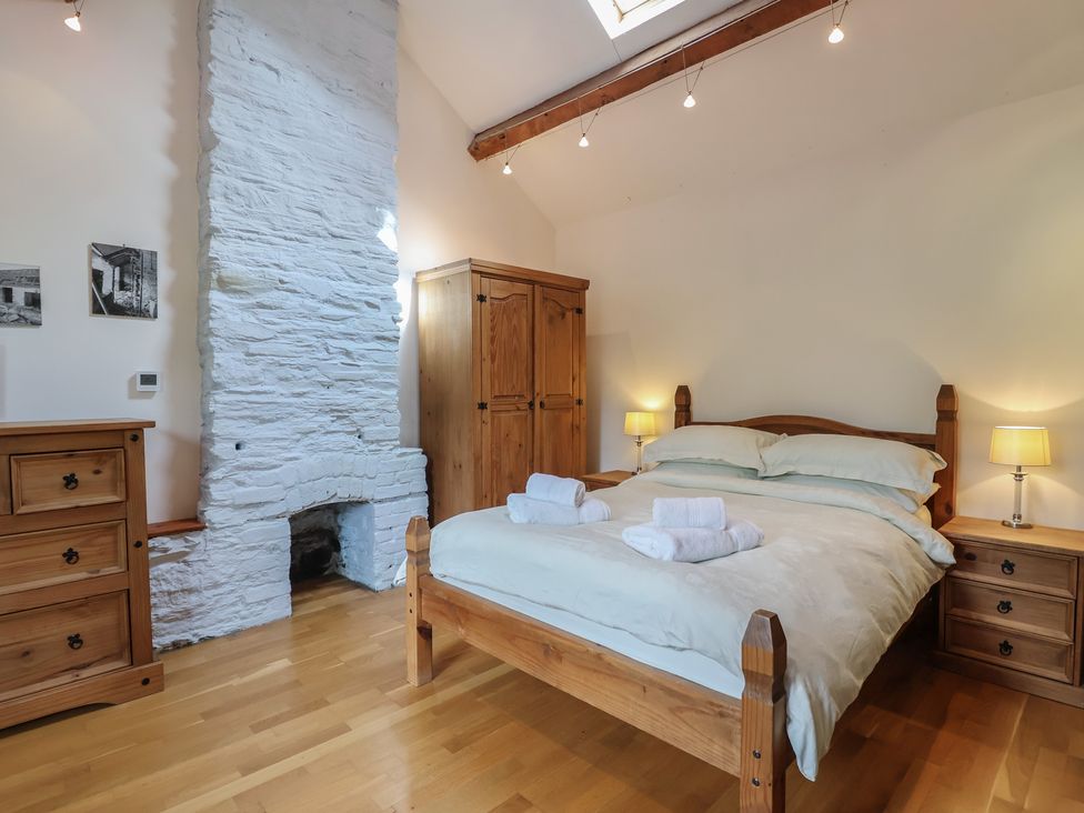 A bedroom with a bed and wardrobe at The Coach House in Tavistock