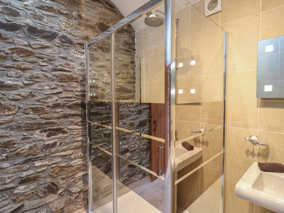 A bathroom with a shower and sink at The Coach House in Tavistock