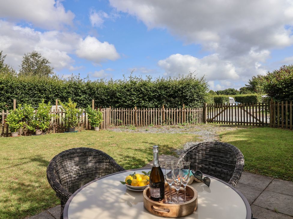 A garden with a table, chairs, and plants at The Coach House in Tavistock