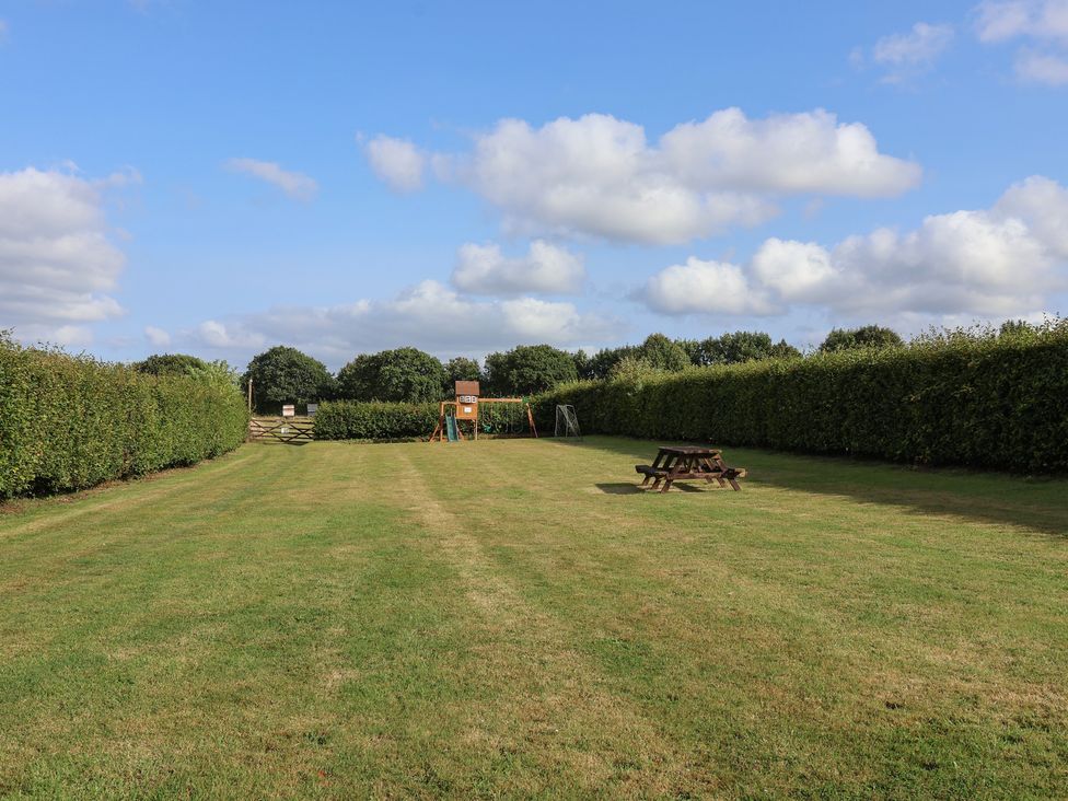 A garden area with playground and seating at The Coach House in Tavistock