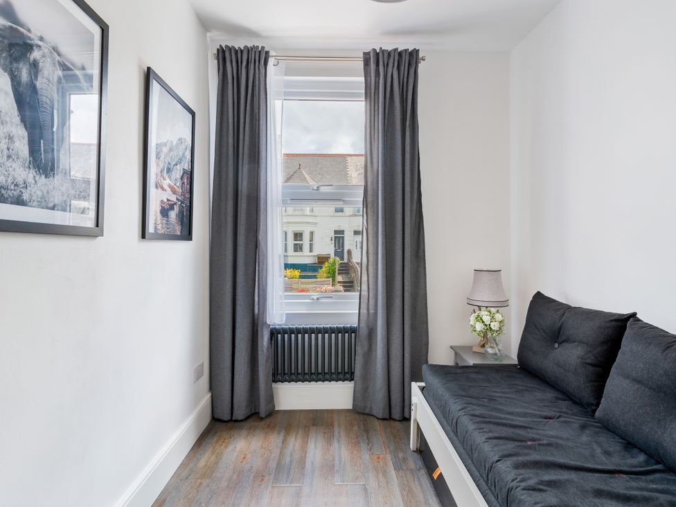 A living room with a sofa and window at The Sundial in St Austell