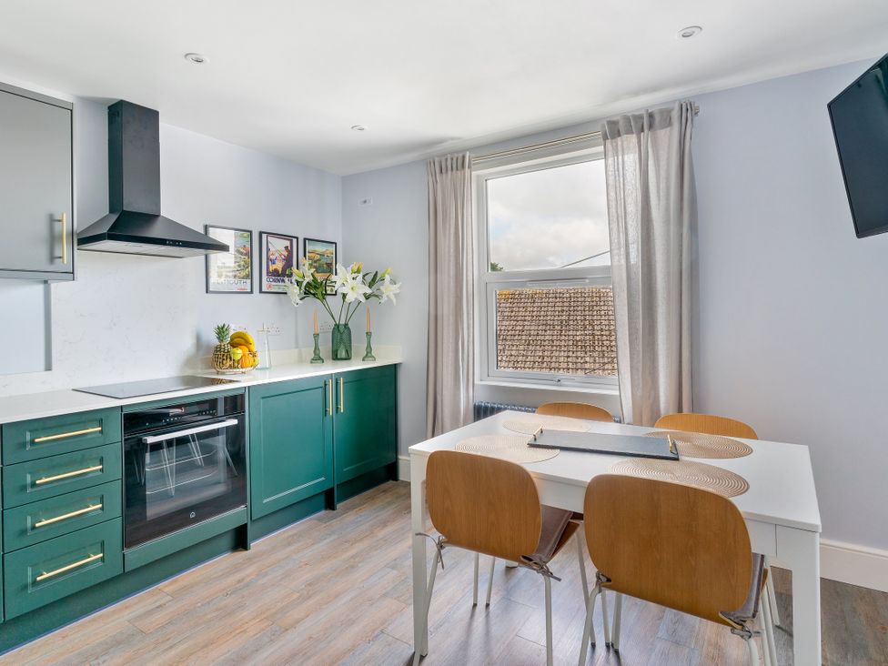 A kitchen with a dining table and chairs at The Sundial in St Austell