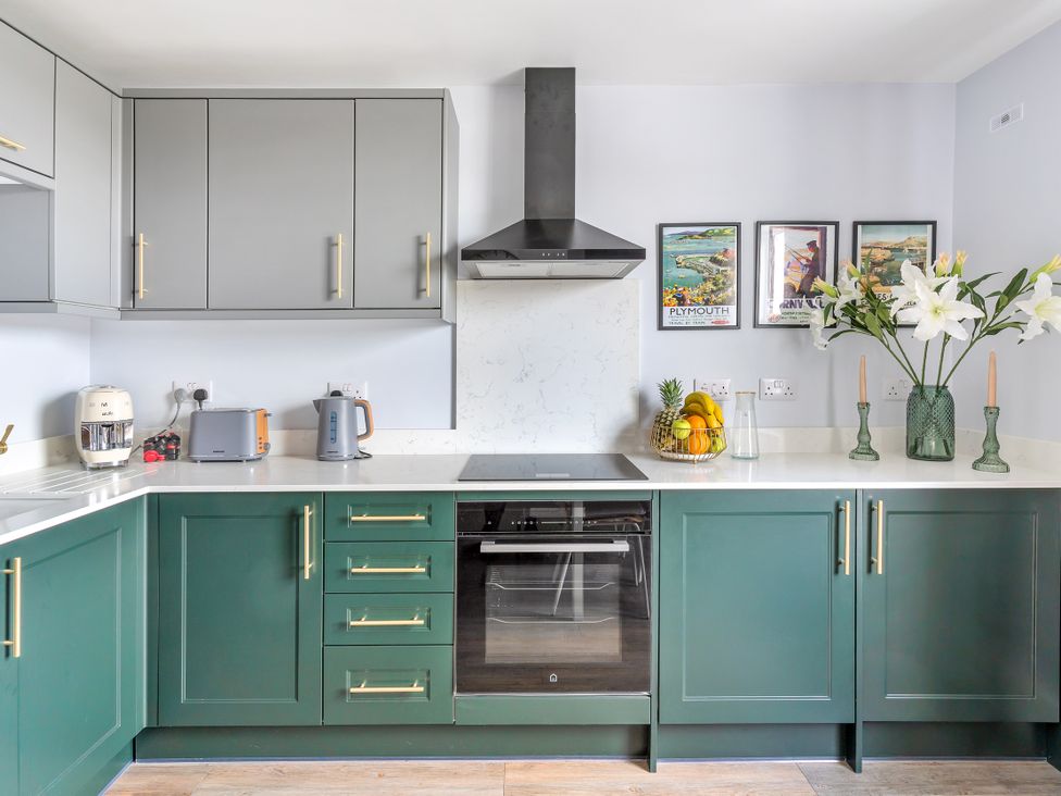 A kitchen with cabinets and appliances at The Sundial St Austell