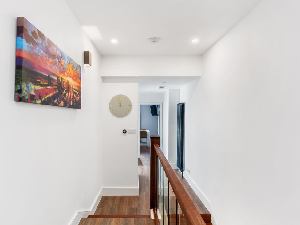 A hallway with a painting and clock at The Sundial in St Austell
