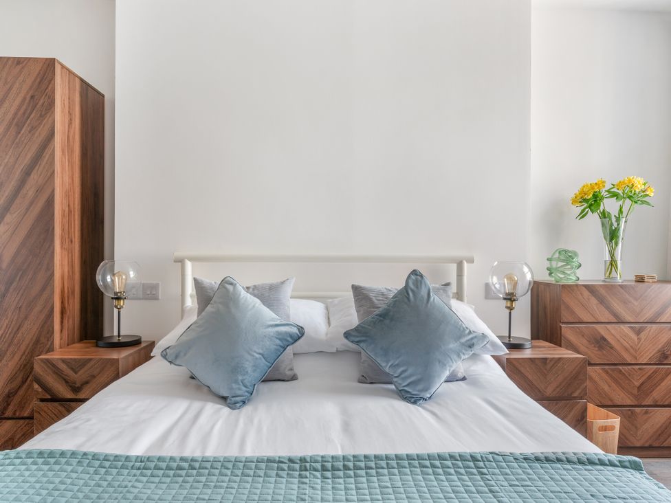 A bedroom with a bed and nightstands at The Sundial in St Austell