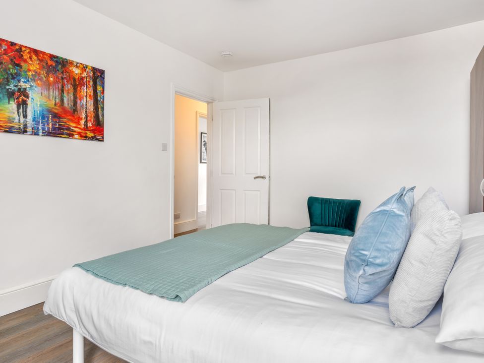 A bedroom with a bed and painting at The Sundial in St Austell