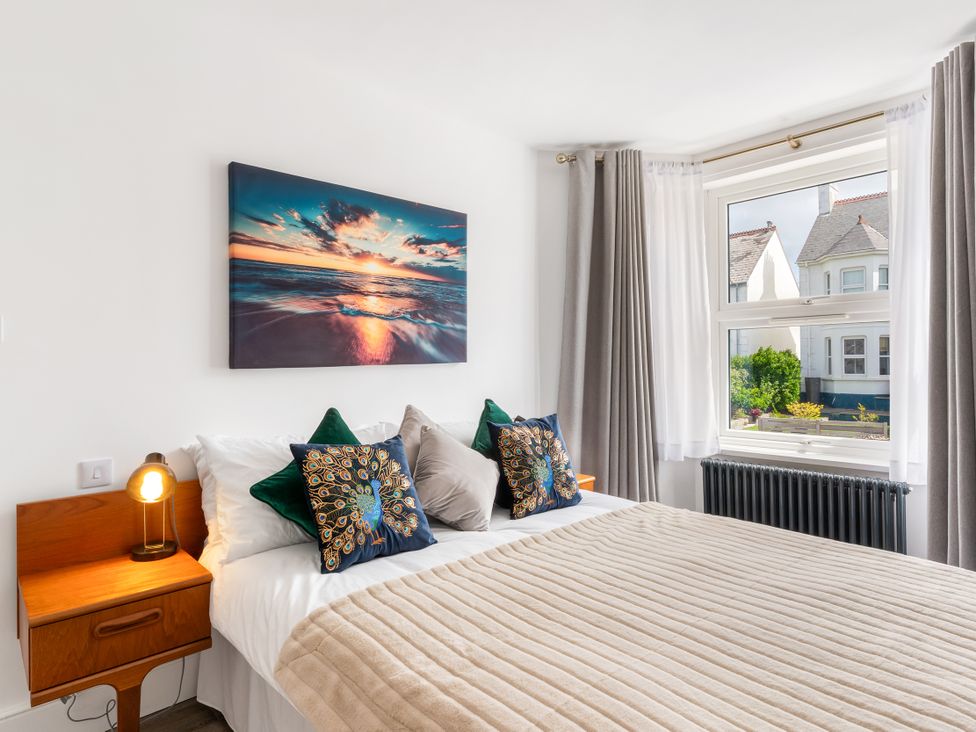 A bedroom with a bed and a window at The Sundial in St Austell