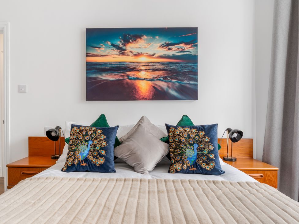 A bedroom with a bed and decorative pillows at The Sundial in St Austell