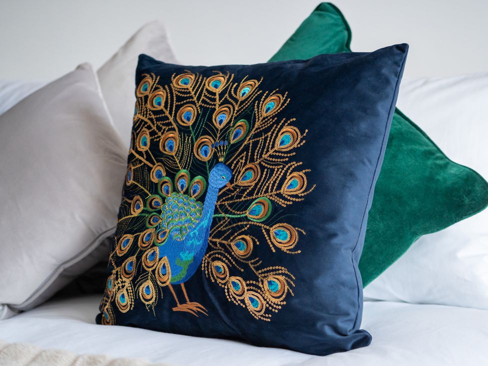 A decorative cushion with a peacock design at The Sundial in St Austell