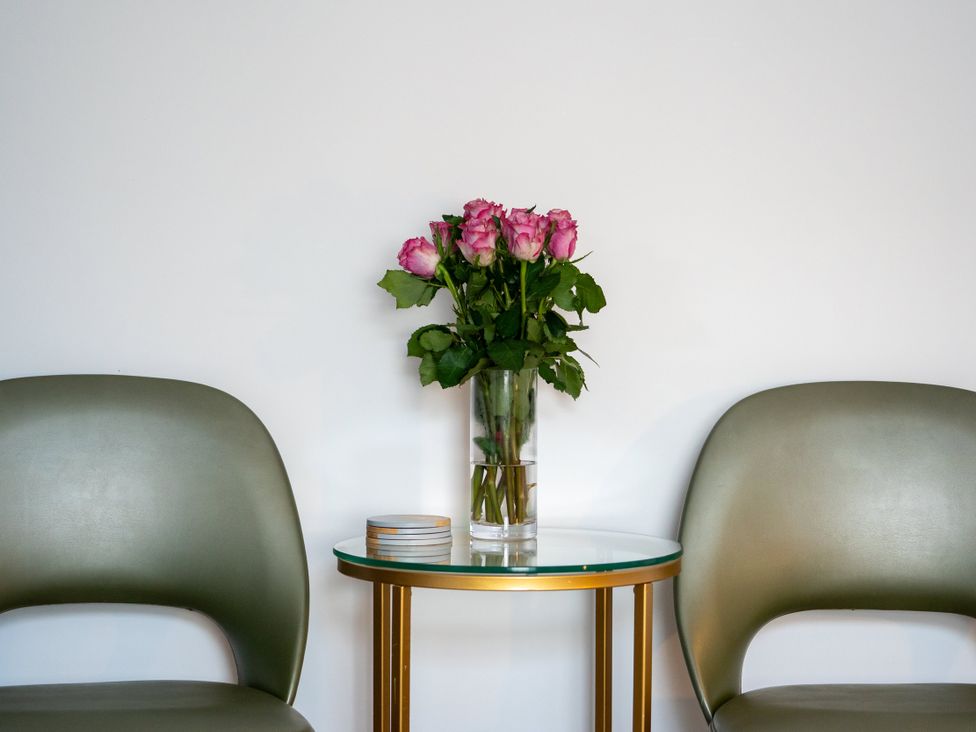 A living room with a table and flowers at The Sundial in St Austell