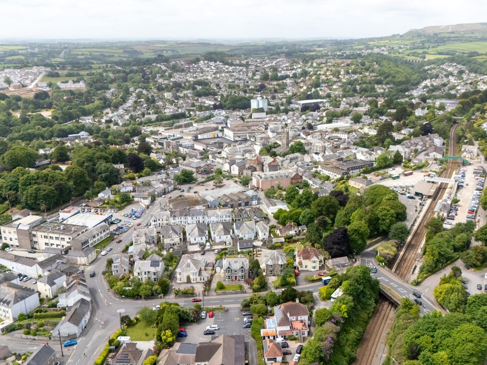 An aerial view of a town with buildings, roads, and greenery at The Sundial in St Austell