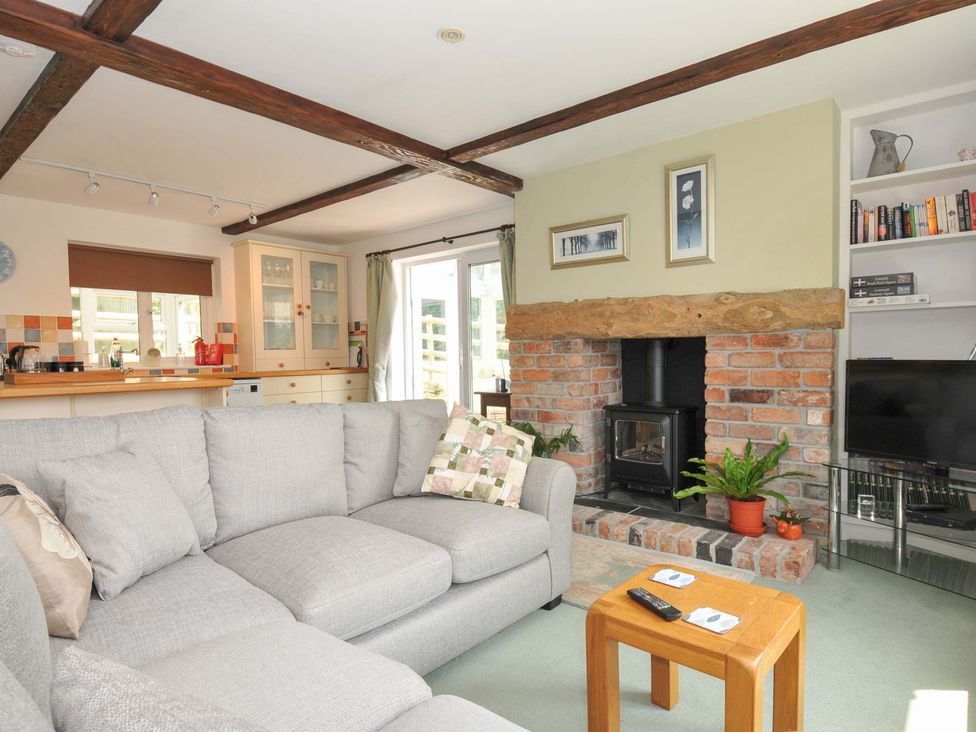 A living room with a fireplace and sofa at Upper Court Cottage in Broad Langdon near Wainhouse Corner
