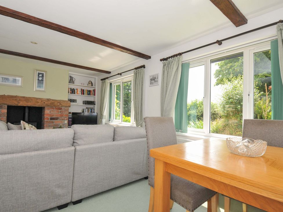A living room with a sofa and dining table at Upper Court Cottage in Broad Langdon near Wainhouse Corner