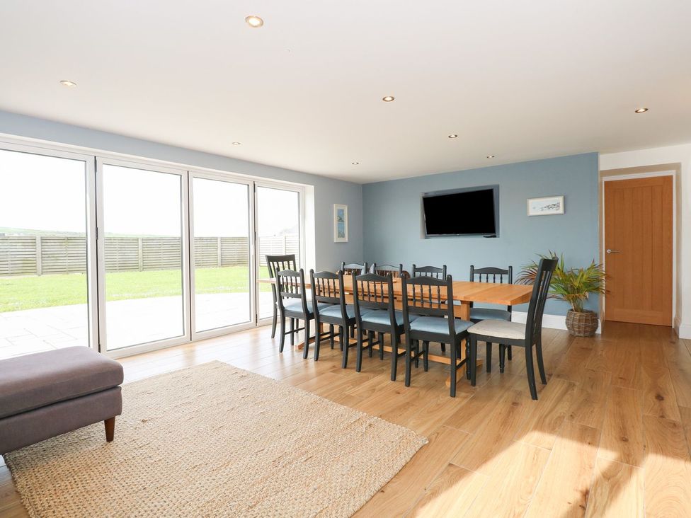 A dining room with a table and chairs at Criw in Bryncroes near Sarn Meyllteyrn