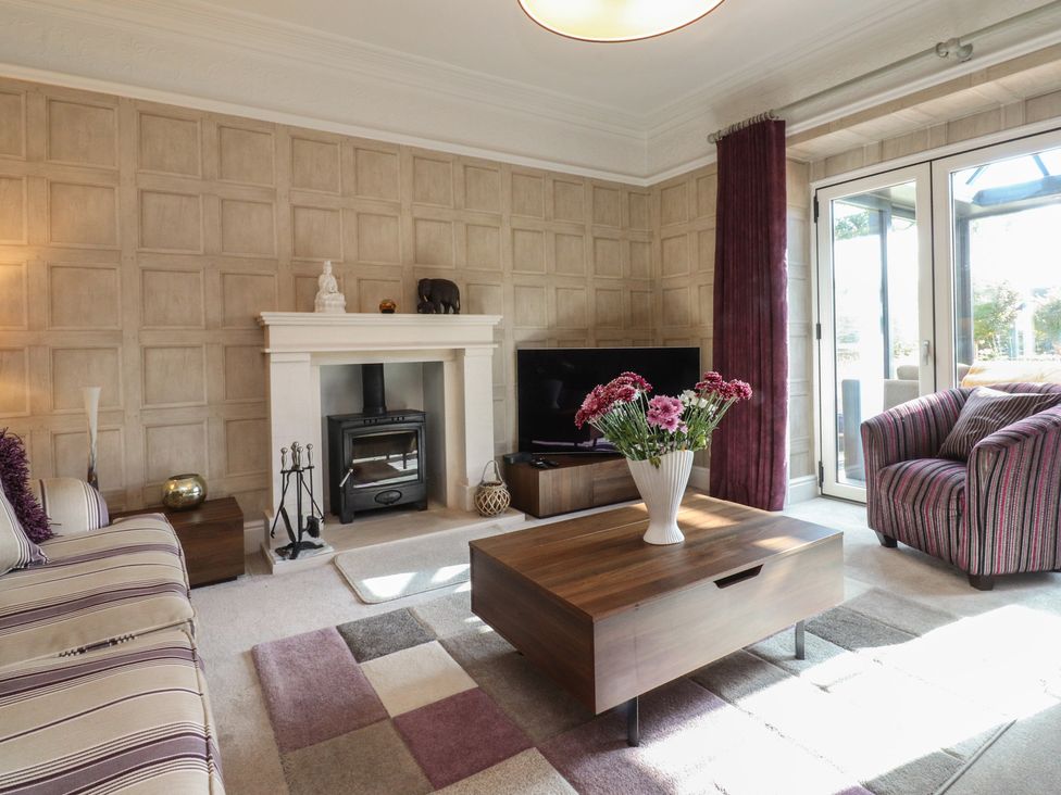 A living room with a fireplace and sofa at Langcliffe House in Kettlewell