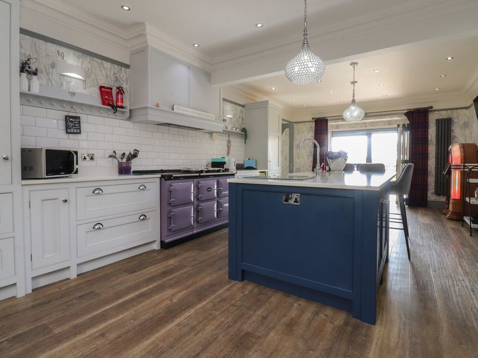 A kitchen with microwave and kitchen island at Langcliffe House in Kettlewell