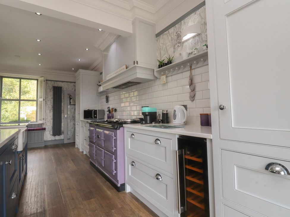 A kitchen with a stove, microwave, and wine cooler at Langcliffe House, Kettlewell