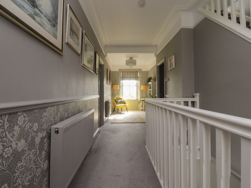 A hallway with a staircase and pictures at Langcliffe House in Kettlewell