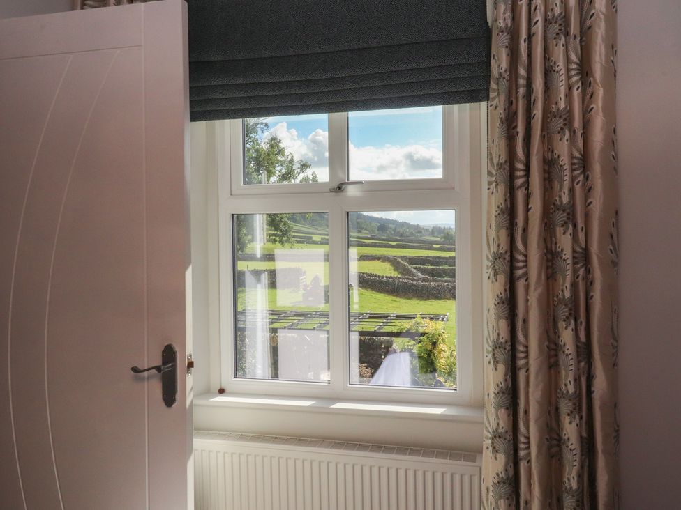 A window with a view and curtains at Langcliffe House Kettlewell