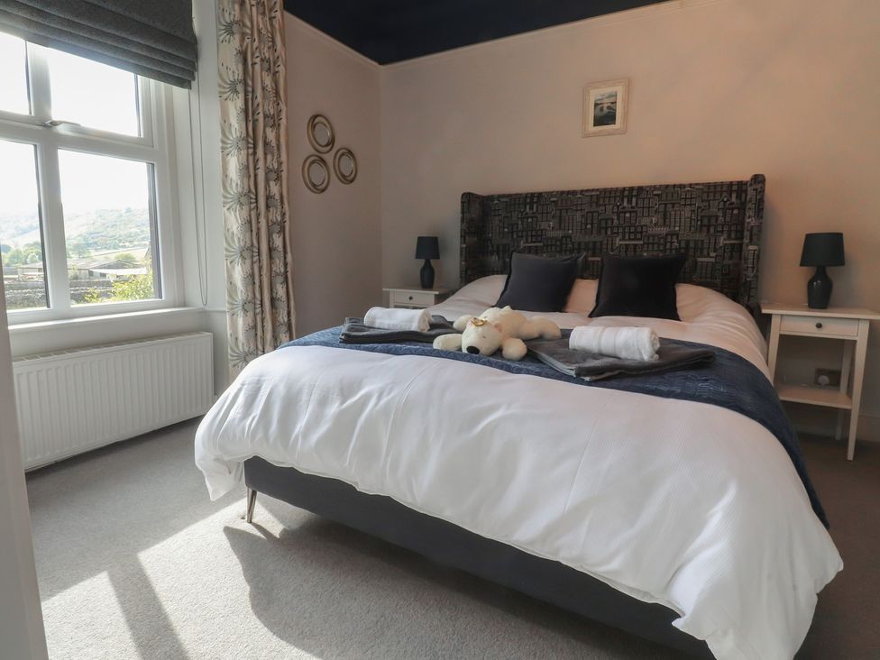 A bedroom with a bed and nightstand at Langcliffe House in Kettlewell