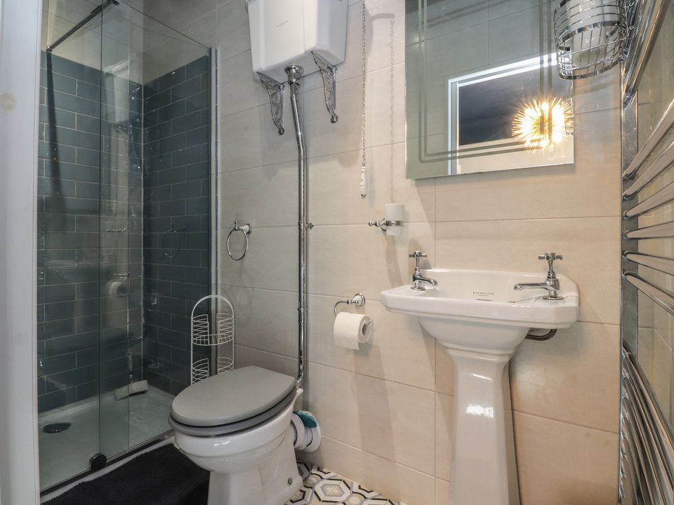 A bathroom with a shower, toilet, and sink at Langcliffe House in Kettlewell