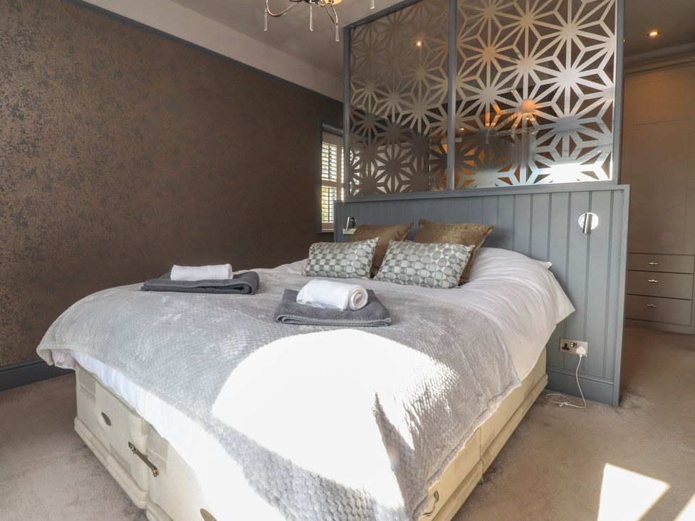 A bedroom with a bed and decorative screen at Langcliffe House in Kettlewell