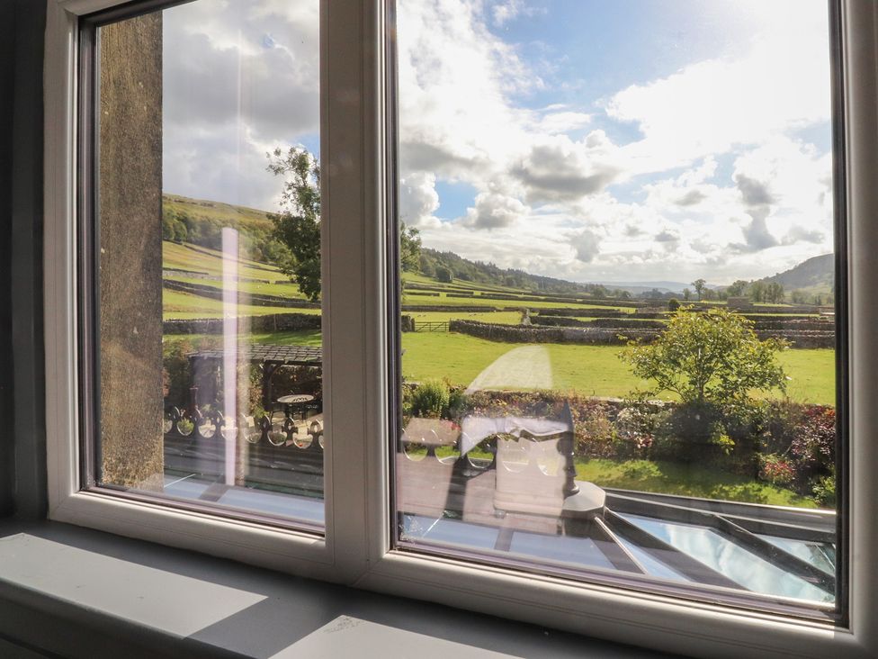 A view from a window showing a garden and landscape at Langcliffe House Kettlewell