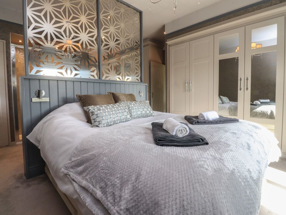 A bedroom with a bed and wardrobe at Langcliffe House in Kettlewell
