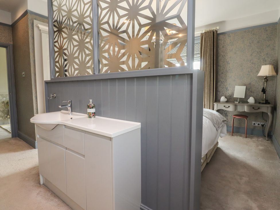 A bedroom with a partition and washbasin at Langcliffe House Kettlewell