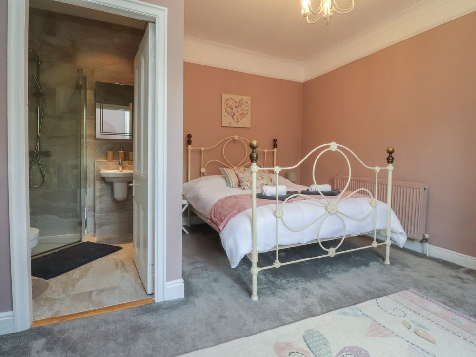 A bedroom with a bed and adjoining bathroom at Langcliffe House Kettlewell