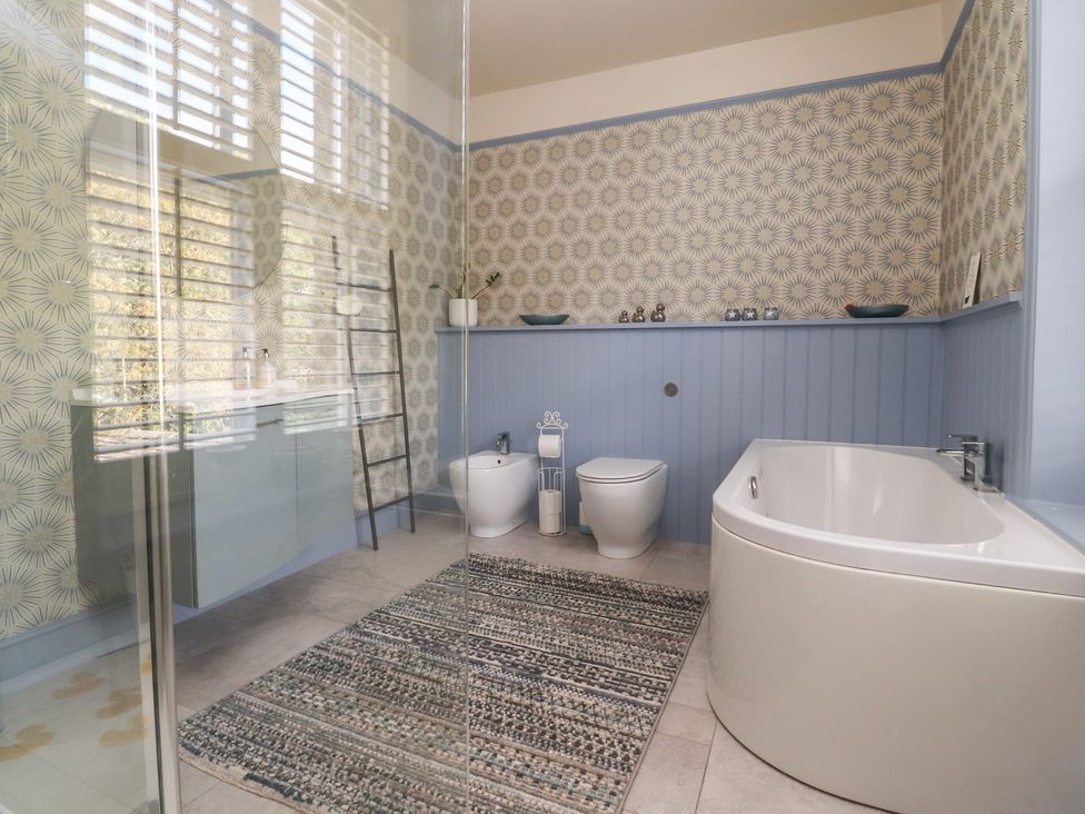 A bathroom with a bathtub, toilet, and sink at Langcliffe House in Kettlewell