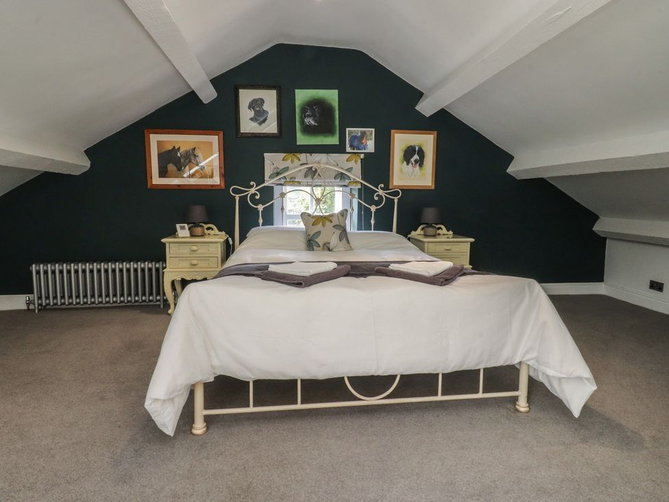 A bedroom with a bed and paintings at Langcliffe House in Kettlewell