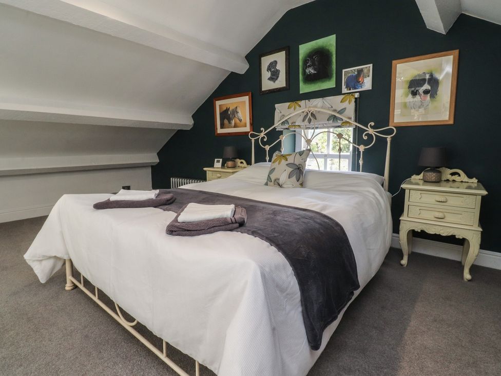A bedroom with a bed and wall art at Langcliffe House in Kettlewell
