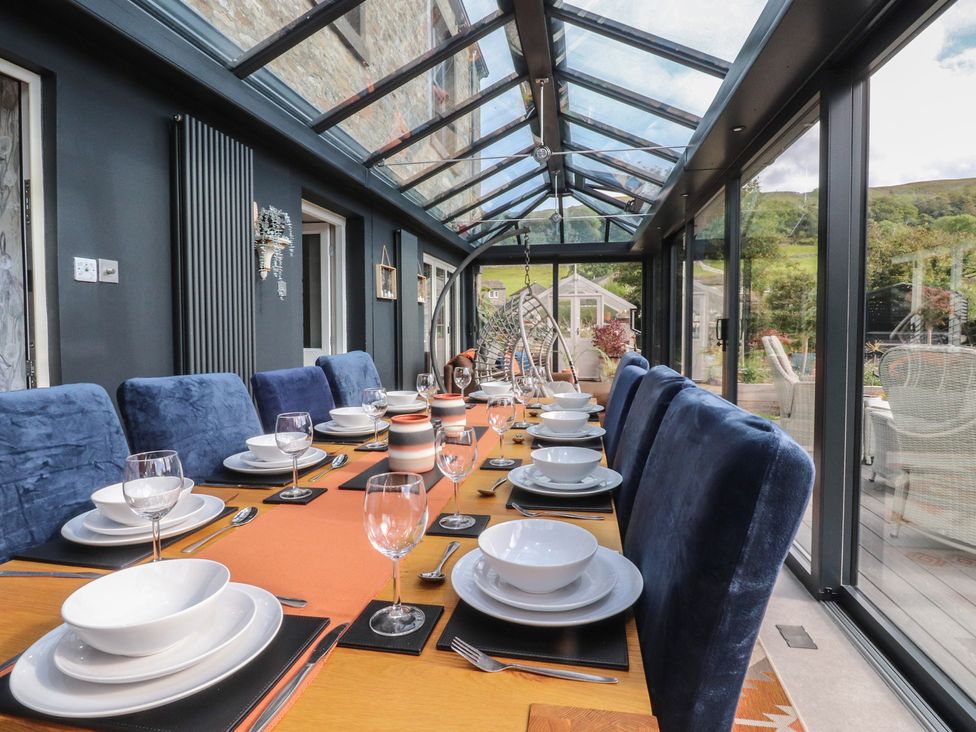 A dining room with a table set for a meal at Langcliffe House in Kettlewell
