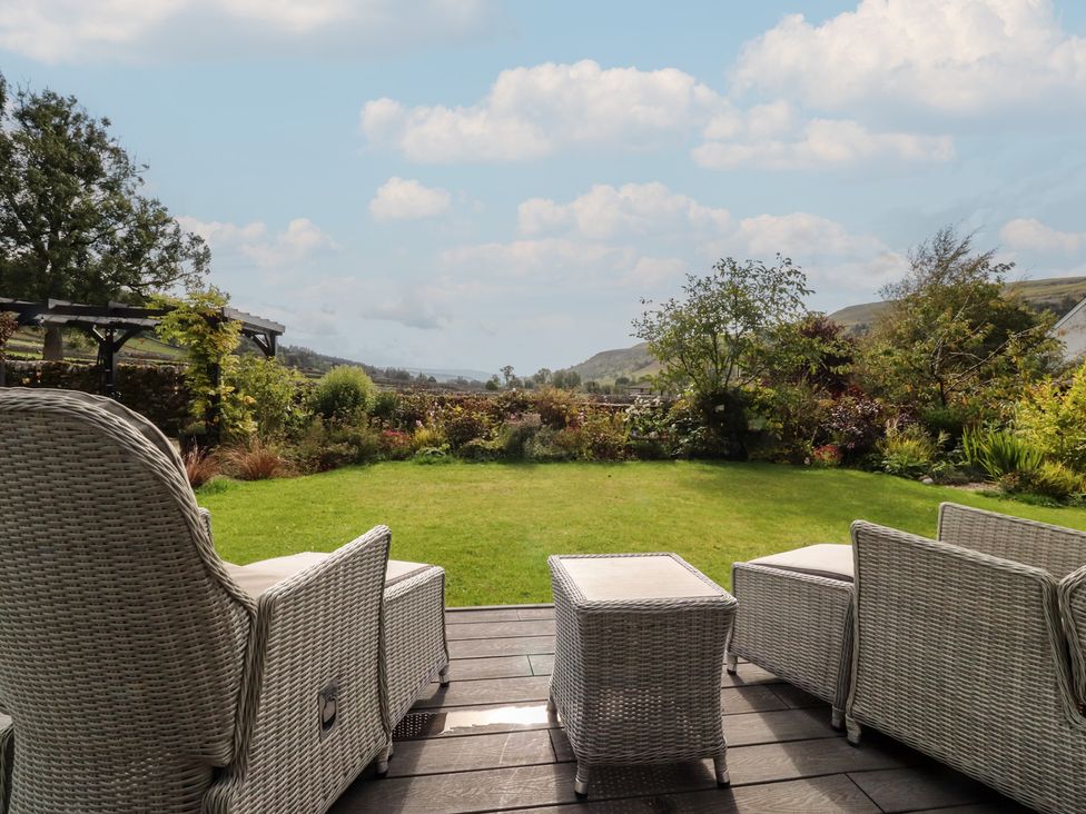 A garden with chairs and a table at Langcliffe House in Kettlewell