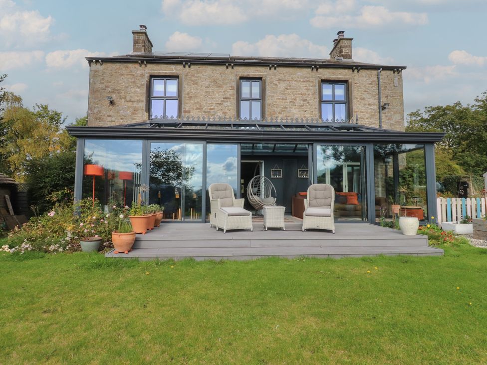 A house with a deck and chairs at Langcliffe House in Kettlewell