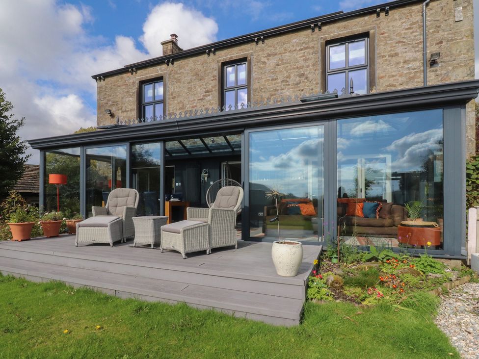 A garden with chairs and pots at Langcliffe House in Kettlewell