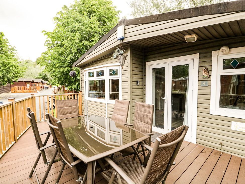 An outdoor patio with a table and chairs at Owls Nook Lodge, Langdale 9, White Cross Bay near Windermere