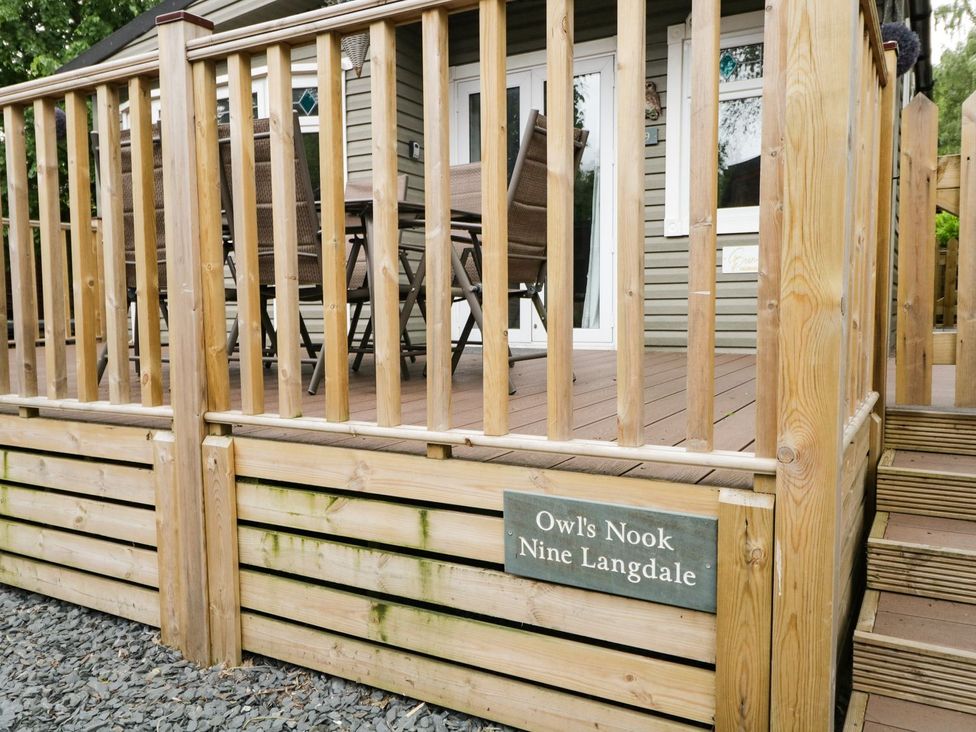 An outdoor deck area with a table and chairs at Owls Nook Lodge, Langdale 9, White Cross Bay near Windermere