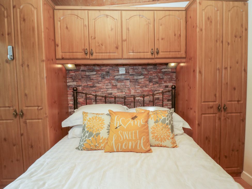 A bedroom with a bed and storage units at Owls Nook Lodge, Langdale 9, White Cross Bay near Windermere