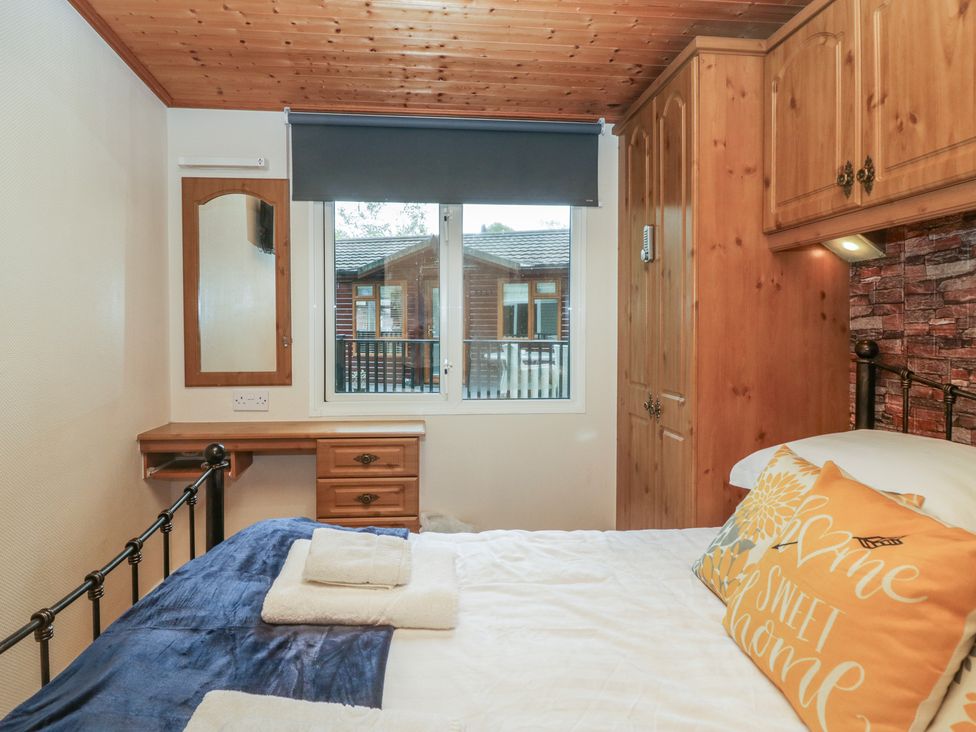 A bedroom with a bed and a window at Owls Nook Lodge near Langdale 9, White Cross Bay near Windermere