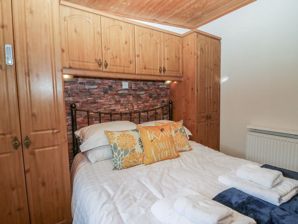 A bedroom with a bed and wardrobe at Owls Nook Lodge, Langdale 9, White Cross Bay near Windermere