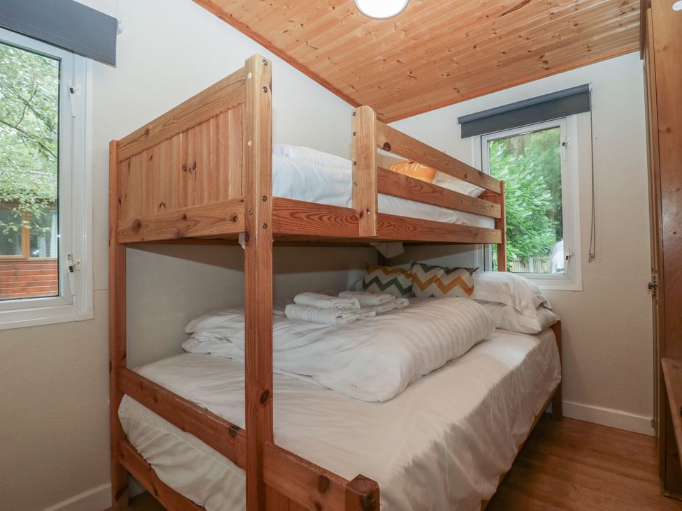 A bedroom with a bunk bed and a double bed at Owls Nook Lodge, Langdale 9, White Cross Bay near Windermere