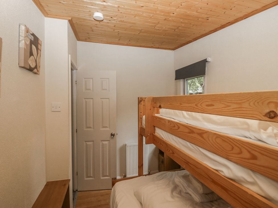 A bedroom with a bunk bed and a door at Owls Nook Lodge, Langdale 9, White Cross Bay near Windermere