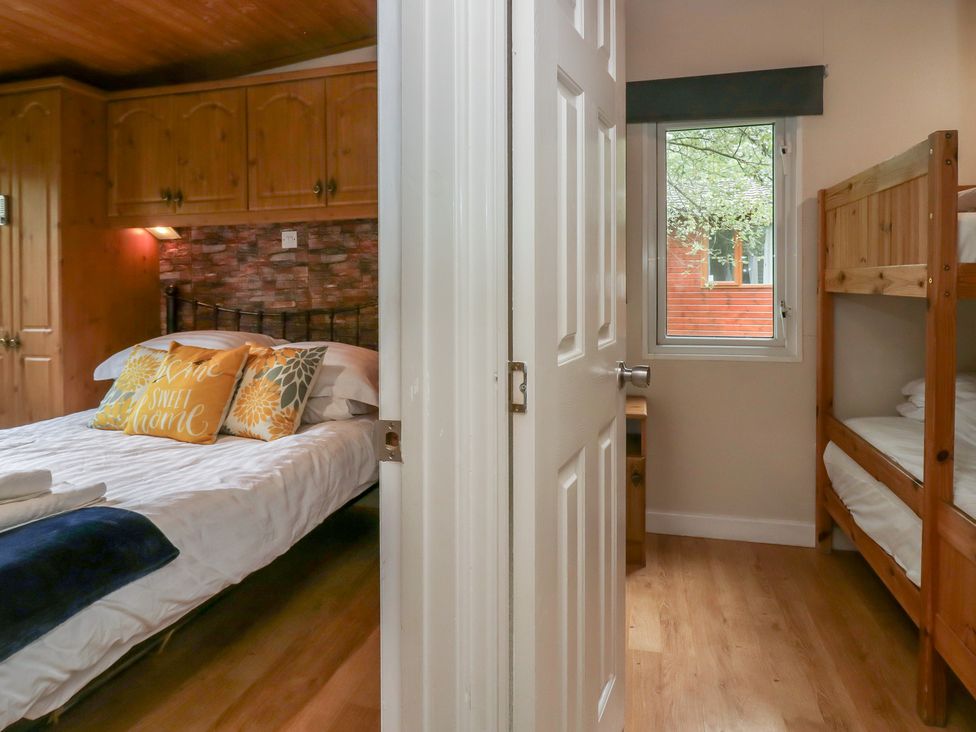A bedroom with a bed and a bunk bed at Owls Nook Lodge Langdale 9, White Cross Bay near Windermere