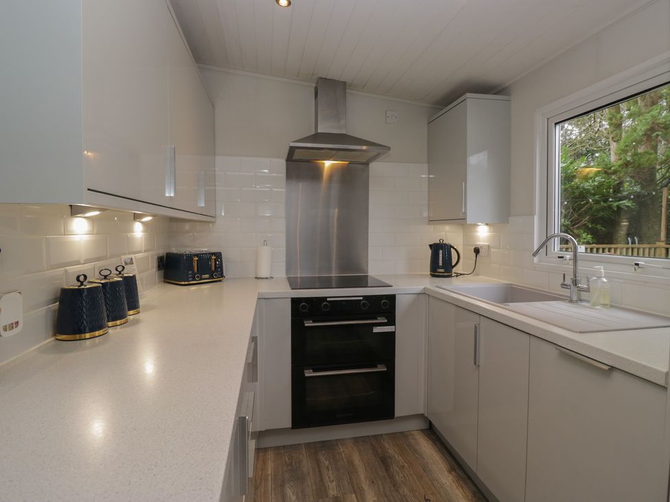 A kitchen with a sink and oven at Owls Nook Lodge Langdale 9 White Cross Bay near Windermere