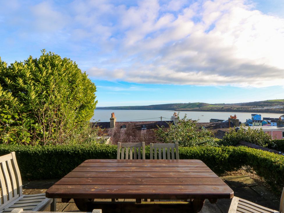 An outdoor seating area with a view over water at Zenobia, New Quay
