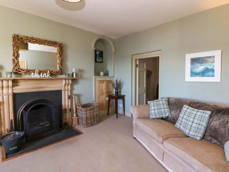 A living room with a sofa and fireplace at Zenobia in New Quay