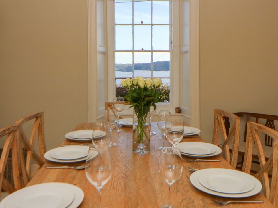 A dining room with a table set for a meal at Zenobia in New Quay